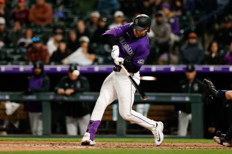 Apr 28, 2025; Denver, Colorado, USA; Colorado Rockies first baseman Michael Toglia (4) hits a single in the sixth inning against the Atlanta Braves at Coors Field. Mandatory Credit: Isaiah J. Downing-Imagn Images