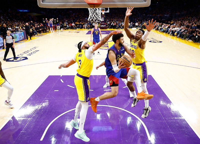 LOS ANGELES, CALIFORNIA - APRIL 25:   Jamal Murray #27 of the Denver Nuggets passes the ball against Anthony Davis #3 and Rui Hachimura #28 of the Los Angeles Lakers in the second half during game three of the Western Conference First Round Playoffs at Crypto.com Arena on April 25, 2024 in Los Angeles, California.  (Photo by Ronald Martinez/Getty Images)