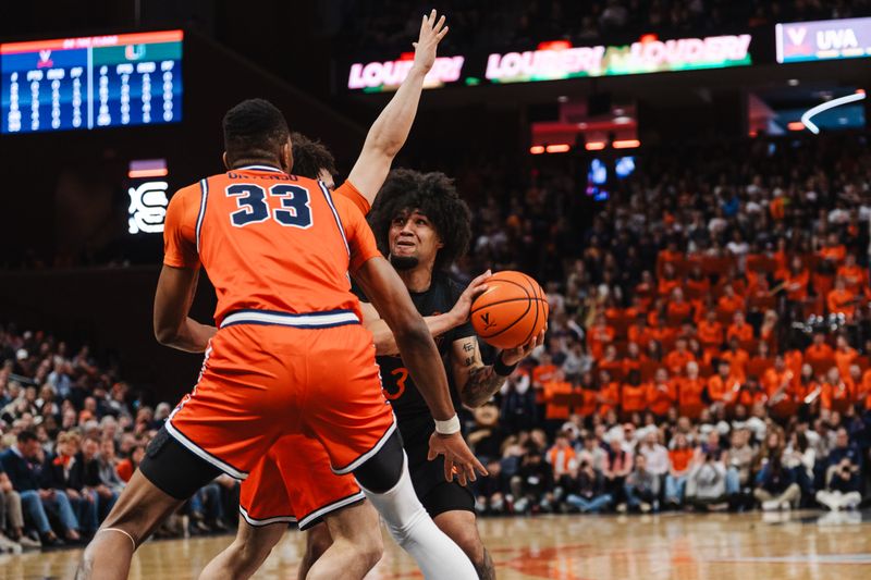 Feb 21, 2026; Charlottesville, Virginia, USA; Miami (FL) Hurricanes forward Malik Reneau (5) controls the ball while Virginia Cavaliers guard Chance Mallory (2) and  center Ugonna Onyenso (33) defend during the first half at John Paul Jones Arena. Mandatory Credit: Emily Faith Morgan-Imagn Images