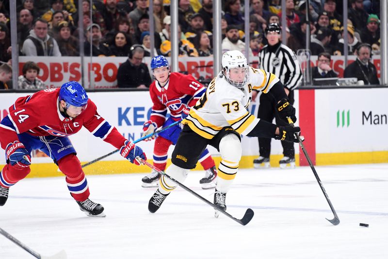 Jan 24, 2026; Boston, Massachusetts, USA; Montreal Canadiens center Nick Suzuki (14) tries to poke the puck from Boston Bruins defenseman Charlie McAvoy (73) during the third period at TD Garden. Mandatory Credit: Bob DeChiara-Imagn Images