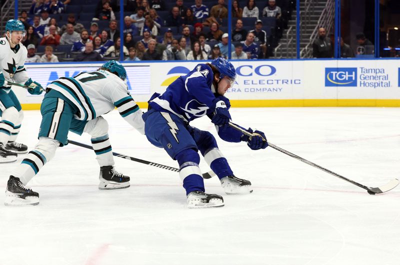 Dec 5, 2024; Tampa, Florida, USA; Tampa Bay Lightning center Conor Geekie (14) skates with the puck as San Jose Sharks defenseman Timothy Liljegren (37) defends during the first period at Amalie Arena. Mandatory Credit: Kim Klement Neitzel-Imagn Images