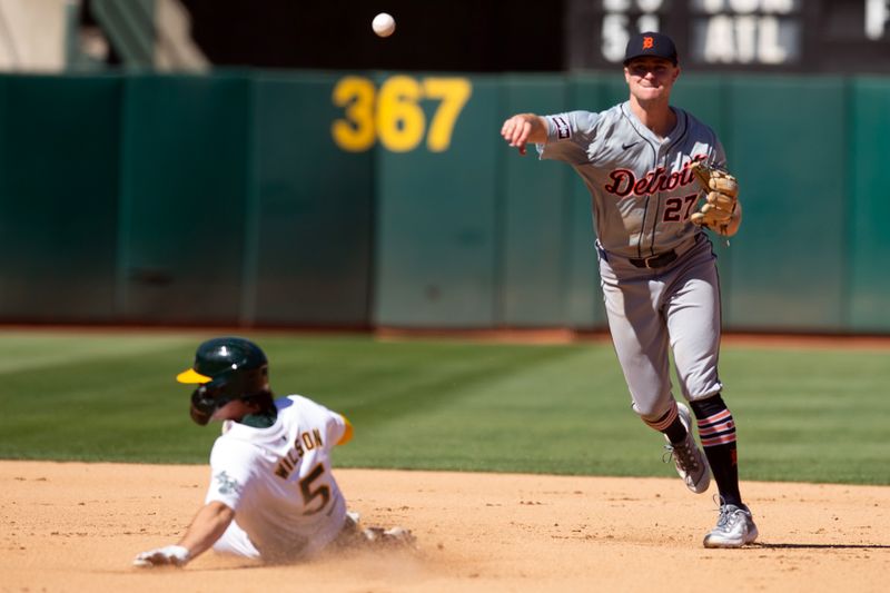 Sep 8, 2024; Oakland, California, USA; Detroit Tigers shortstop Trey Sweeney (27) throws over Oakland Athletics shortstop Jacob Wilson (5) to complete a double play during the seventh inning at Oakland-Alameda County Coliseum. Mandatory Credit: D. Ross Cameron-Imagn Images