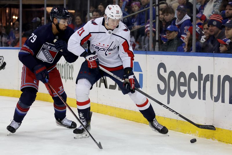 Jan 14, 2024; New York, New York, USA; Washington Capitals center Aliaksei Protas (21) plays the puck against New York Rangers defenseman K'Andre Miller (79) during the first period at Madison Square Garden. Mandatory Credit: Brad Penner-USA TODAY Sports