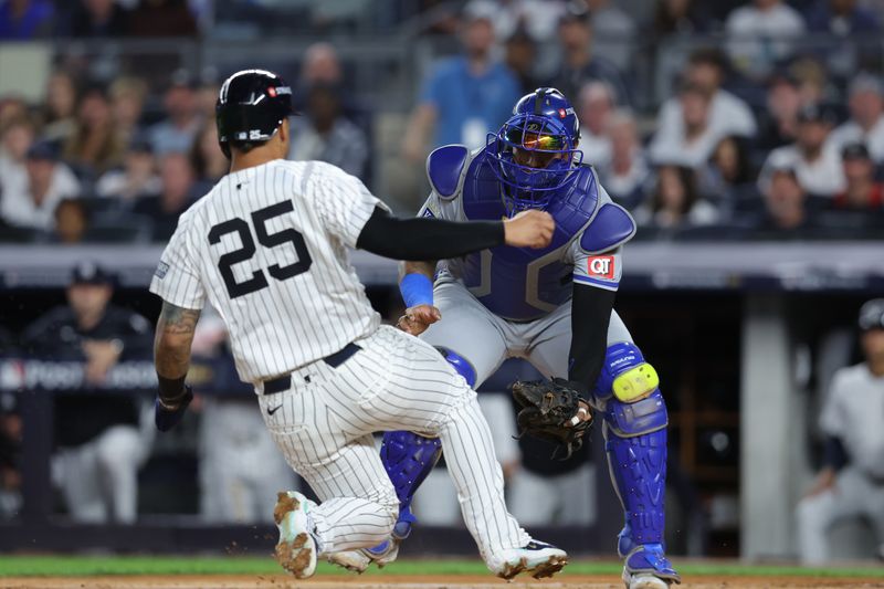 Oct 5, 2024; Bronx, New York, USA; New York Yankees second base Gleyber Torres (25) is tagged out by Kansas City Royals catcher Salvador Perez (13) during the second inning during game one of the ALDS for the 2024 MLB Playoffs at Yankee Stadium. Mandatory Credit: Brad Penner-Imagn Images