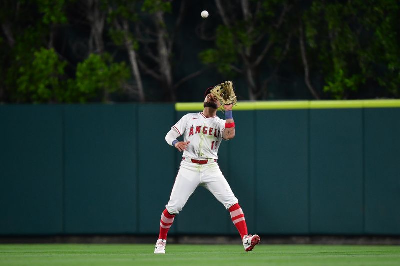 Jun 7, 2024; Anaheim, California, USA; Los Angeles Angels outfielder Kevin Pillar (12) catches the fly ball of Houston Astros shortstop Jeremy Pena (3) during the ninth inning at Angel Stadium. Mandatory Credit: Gary A. Vasquez-USA TODAY Sports