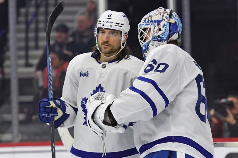 Jan 7, 2025; Philadelphia, Pennsylvania, USA; Toronto Maple Leafs defenseman Chris Tanev (8) and goaltender Joseph Woll (60) celebrate win against the Philadelphia Flyers at Wells Fargo Center. Mandatory Credit: Eric Hartline-Imagn Images