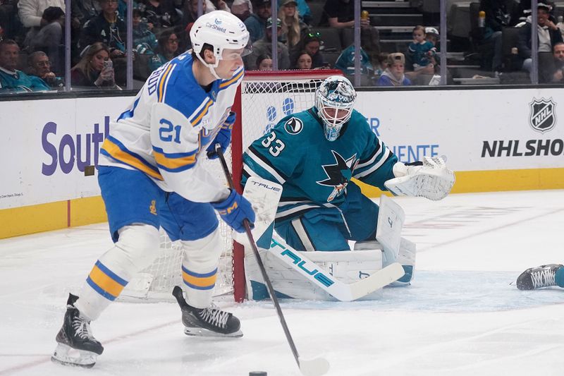 Mar 6, 2026; San Jose, California, USA; San Jose Sharks goaltender Alex Nedeljkovic (33) defends the goal as St. Louis Blues right winger Jimmy Snuggerud (21) handles the puck in the first period at SAP Center at San Jose. Mandatory Credit: David Gonzales-Imagn Images
