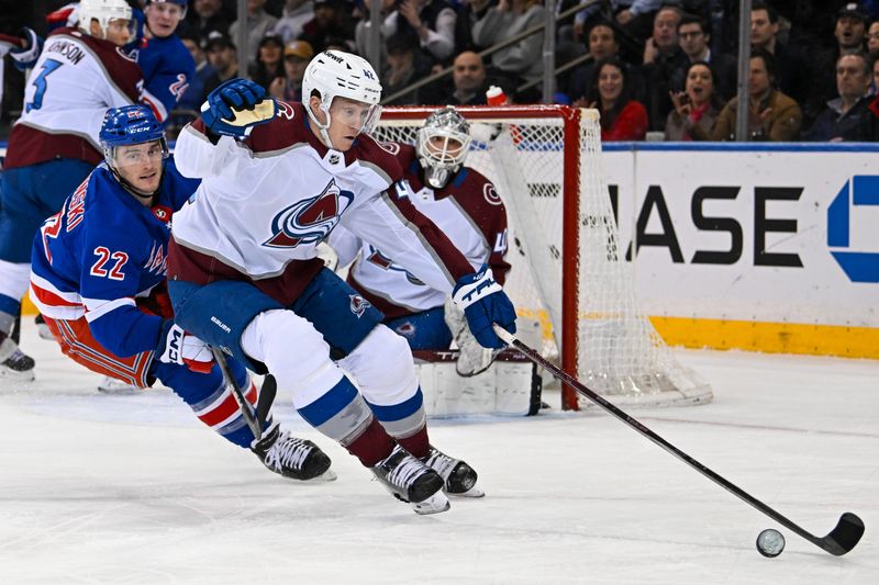 Feb 5, 2024; New York, New York, USA;  Colorado Avalanche defenseman Josh Manson (42) attempts to control the puck chased by New York Rangers center Jonny Brodzinski (22) during the first period at Madison Square Garden. Mandatory Credit: Dennis Schneidler-USA TODAY Sports