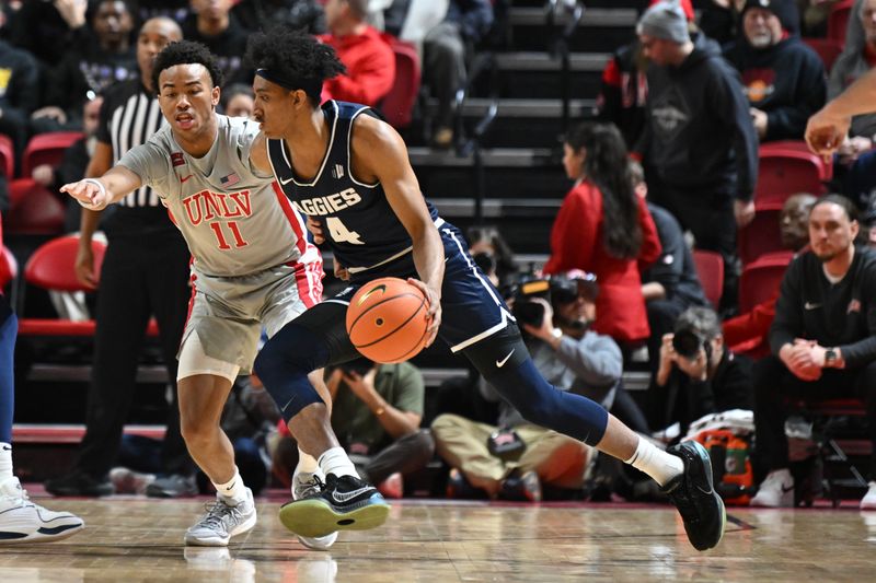 Jan 13, 2024; Las Vegas, Nevada, USA; Utah State Aggies guard Ian Martinez (4) drives past UNLV Rebels guard Dedan Thomas Jr. (11) in the first half at Thomas & Mack Center. Mandatory Credit: Candice Ward-USA TODAY Sports