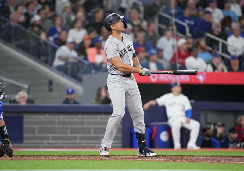 Apr 17, 2024; Toronto, Ontario, CAN; New York Yankees designated hitter Giancarlo Stanton (27) hits a home run against the Toronto Blue Jays during the ninth inning at Rogers Centre. Mandatory Credit: Nick Turchiaro-USA TODAY Sports