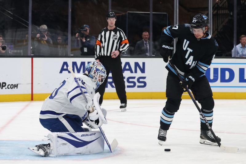 Mar 10, 2025; Salt Lake City, Utah, USA; Utah Hockey Club center Barrett Hayton (27) looks for a shot on Toronto Maple Leafs goaltender Joseph Woll (60) during the third period at Delta Center. Mandatory Credit: Rob Gray-Imagn Images