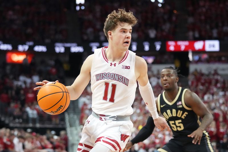 Feb 4, 2024; Madison, Wisconsin, USA; Wisconsin Badgers guard Max Klesmit (11) dribbles the ball against Purdue Boilermakers guard Lance Jones (55) during the first half at the Kohl Center. Mandatory Credit: Kayla Wolf-USA TODAY Sports