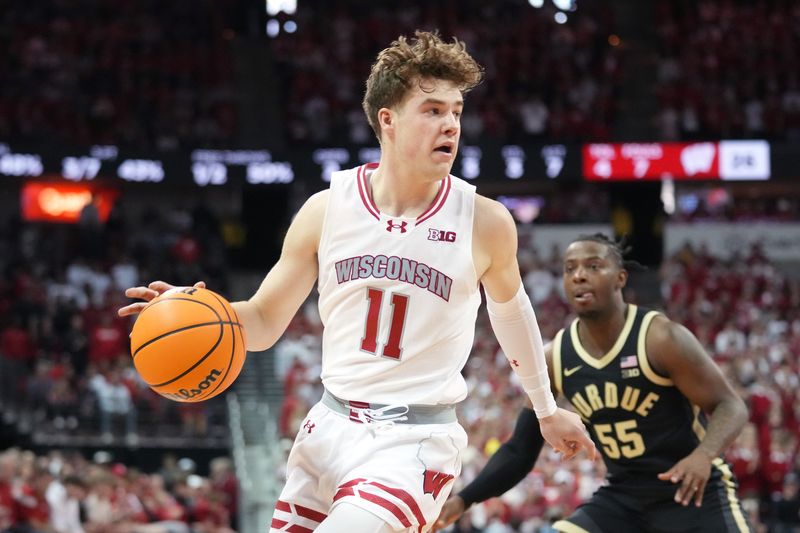 Feb 4, 2024; Madison, Wisconsin, USA; Wisconsin Badgers guard Max Klesmit (11) dribbles the ball against Purdue Boilermakers guard Lance Jones (55) during the first half at the Kohl Center. Mandatory Credit: Kayla Wolf-USA TODAY Sports