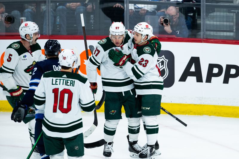 Feb 20, 2024; Winnipeg, Manitoba, CAN; Minnesota Wild forward Marco Rossi(23) is congratulated by his team mates on his goal against the Winnipeg Jets during the third period at Canada Life Centre. Mandatory Credit: Terrence Lee-USA TODAY Sports