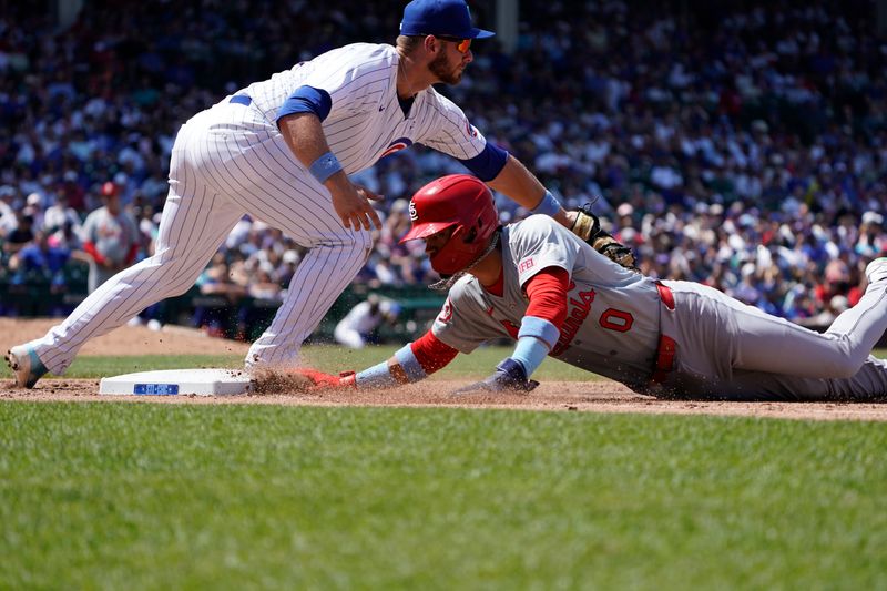 Jun 16, 2024; Chicago, Illinois, USA; St. Louis Cardinals shortstop Masyn Winn (0) is safe at first base as Chicago Cubs first baseman Michael Busch (29) makes a late tag during the eighth inning at Wrigley Field. Mandatory Credit: David Banks-USA TODAY Sports