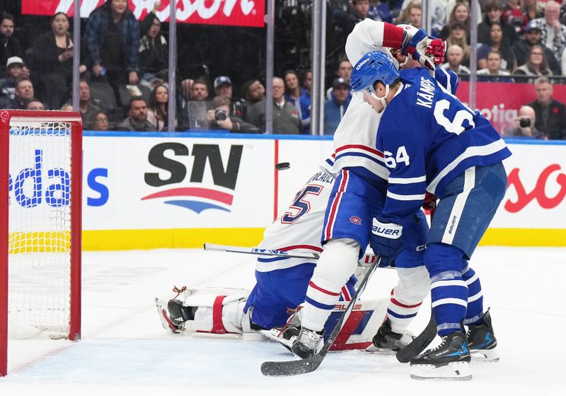 Nov 9, 2024; Toronto, Ontario, CAN; Toronto Maple Leafs center David Kampf (64) battles in front of the net as a puck goes past Montreal Canadiens goaltender Sam Montembeault (35) for a goal during the first period at Scotiabank Arena. Mandatory Credit: Nick Turchiaro-Imagn Images