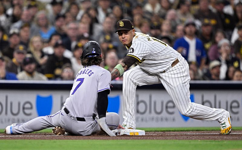 May 13, 2024; San Diego, California, USA; Colorado Rockies second baseman Brendan Rodgers (7) slides into third base ahead of the tag by San Diego Padres third baseman Manny Machado (13) during the sixth inning at Petco Park. Mandatory Credit: Orlando Ramirez-USA TODAY Sports