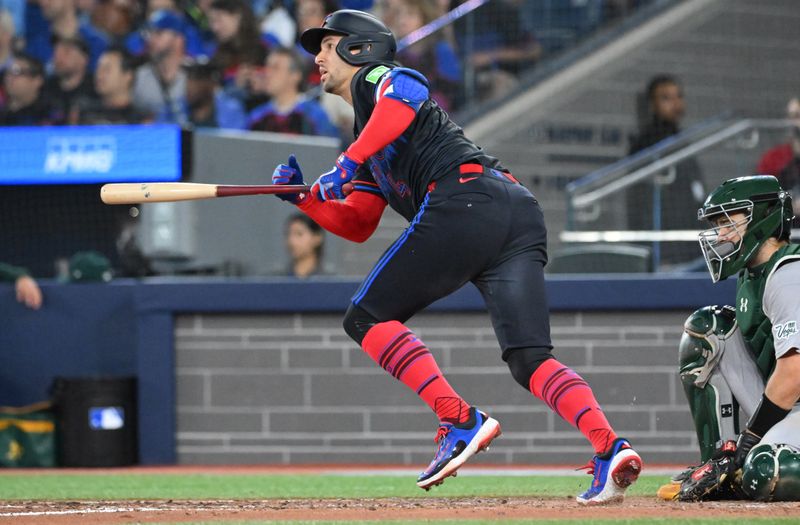 May 30, 2025; Toronto, Ontario, CAN;  Toronto Blue Jays designated hitter George Springer (4) hits an RBI single against the Athletics in the fifth inning at Rogers Centre. Mandatory Credit: Dan Hamilton-Imagn Images