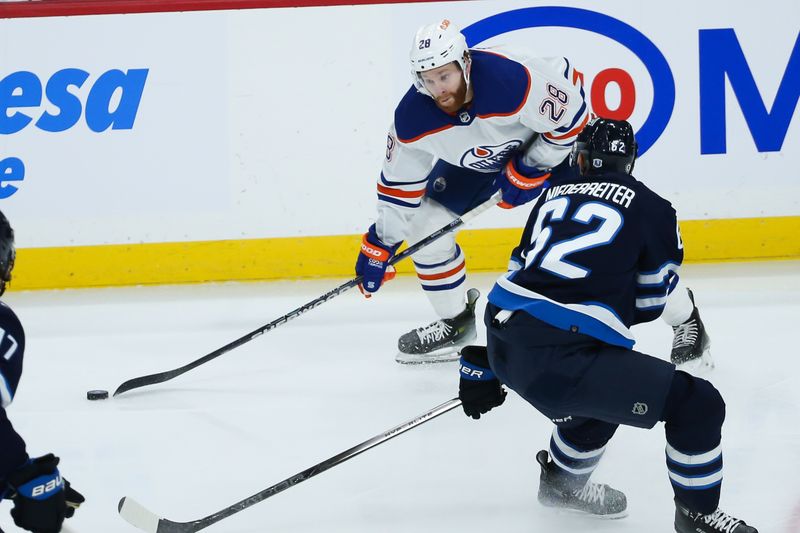 Nov 30, 2023; Winnipeg, Manitoba, CAN; Edmonton Oilers forward Connor Brown (28) looks to make a pass by Winnipeg Jets forward Nino Niederreiter (62) during the third period at Canada Life Centre. Mandatory Credit: Terrence Lee-USA TODAY Sports