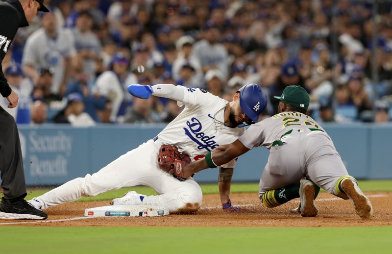 May 14, 2025; Los Angeles, California, USA; Athletics outfielder Miguel Andujar (22) tags out Los Angeles Dodgers outfielder Andy Pages (44) during the sixth inning at Dodger Stadium. Mandatory Credit: Jason Parkhurst-Imagn Images