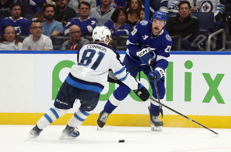 Nov 14, 2024; Tampa, Florida, USA; Tampa Bay Lightning left wing Nick Paul (20) passes the puck as Winnipeg Jets left wing Kyle Connor (81) defends during the third period at Amalie Arena. Mandatory Credit: Kim Klement Neitzel-Imagn Images