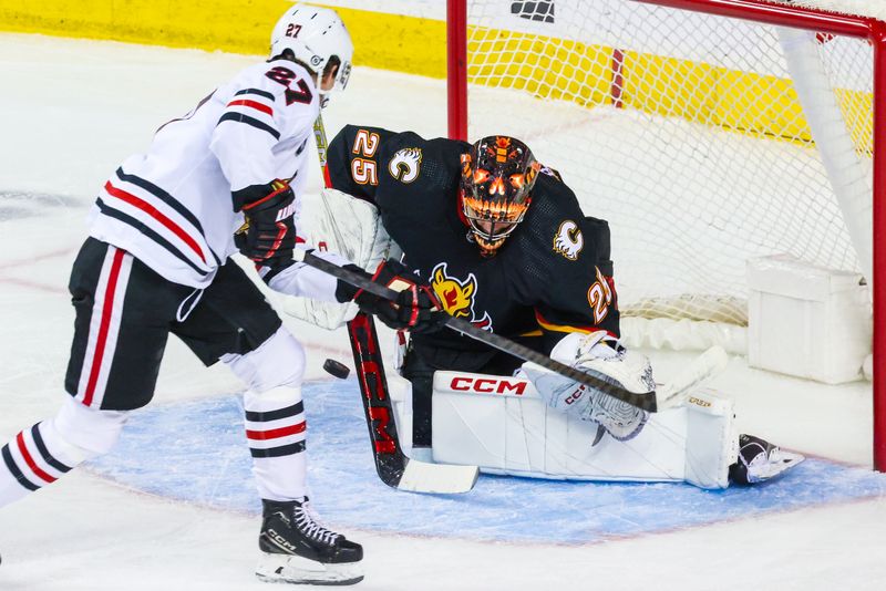 Jan 27, 2024; Calgary, Alberta, CAN; Calgary Flames goaltender Jacob Markstrom (25) makes a save against Chicago Blackhawks left wing Lukas Reichel (27) during the first period at Scotiabank Saddledome. Mandatory Credit: Sergei Belski-USA TODAY Sports