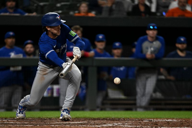 May 13, 2024; Baltimore, Maryland, USA;  Toronto Blue Jays second baseman Ernie Clement (28) bunts in then tenth inning against the Baltimore Orioles at Oriole Park at Camden Yards. Mandatory Credit: Tommy Gilligan-USA TODAY Sports