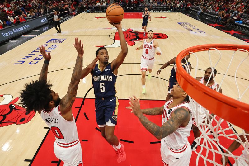 CHICAGO, ILLINOIS - DECEMBER 02: Herbert Jones #5 of the New Orleans Pelicans shoots over Coby White #0 and DeMar DeRozan #11 of the Chicago Bulls during the second half at the United Center on December 02, 2023 in Chicago, Illinois. NOTE TO USER: User expressly acknowledges and agrees that, by downloading and or using this photograph, User is consenting to the terms and conditions of the Getty Images License Agreement.  (Photo by Michael Reaves/Getty Images)