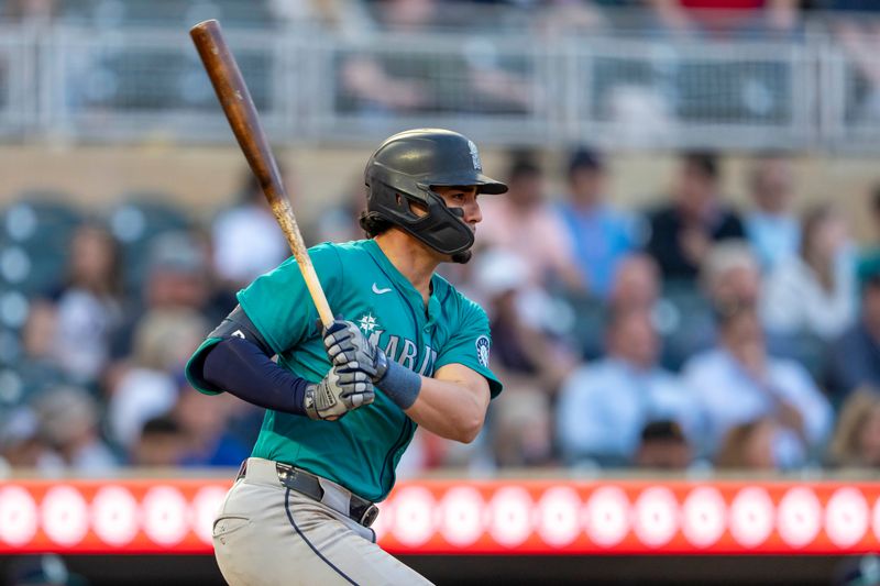 May 8, 2024; Minneapolis, Minnesota, USA; Seattle Mariners third baseman Josh Rojas (4) hits a single against the Minnesota Twins in the fifth inning at Target Field. Mandatory Credit: Jesse Johnson-USA TODAY Sports