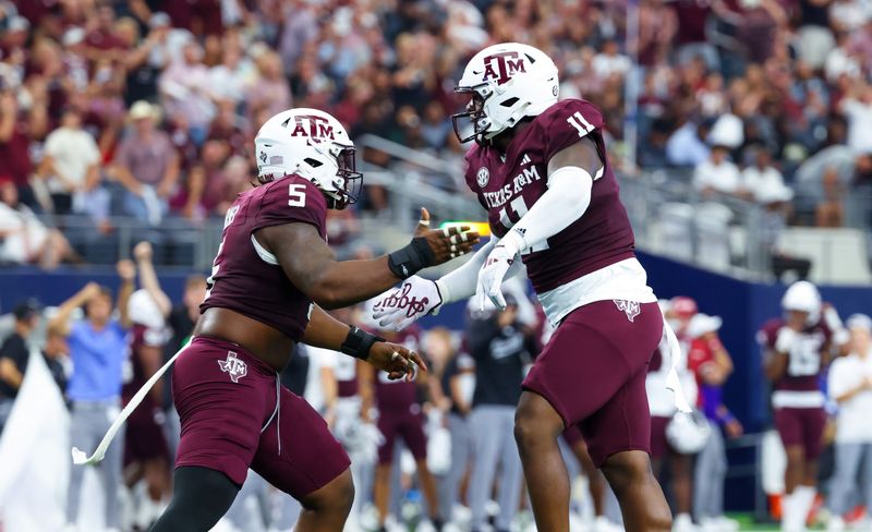 Sep 28, 2024; Arlington, Texas, USA;  Texas A&M Aggies defensive lineman Nic Scourton (11) celebrates with Texas A&M Aggies defensive lineman Shemar Turner (5) during the first half against the Arkansas Razorbacks at AT&T Stadium. Mandatory Credit: Kevin Jairaj-Imagn Images