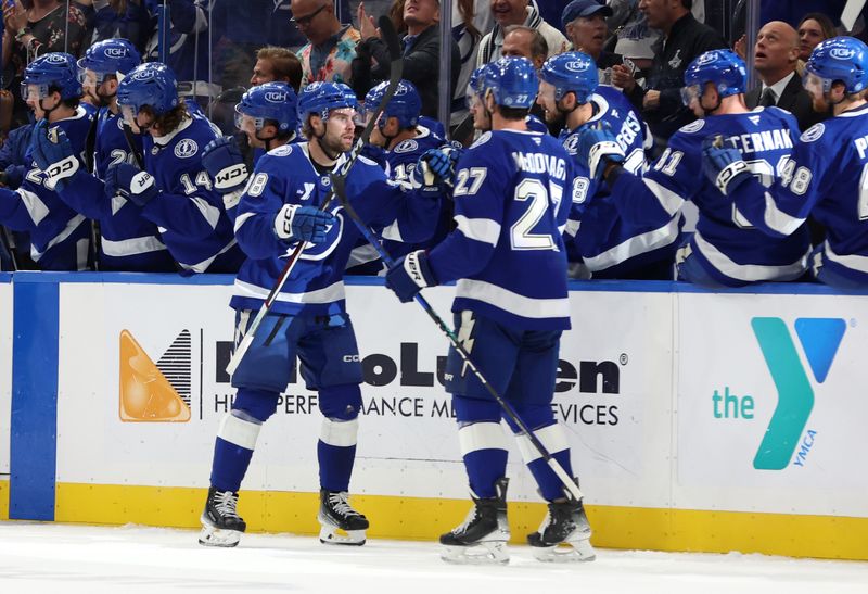 Oct 24, 2024; Tampa, Florida, USA; Tampa Bay Lightning left wing Brandon Hagel (38)n is congratulated by defenseman Ryan McDonagh (27) and teammates after he scored a goal against the Minnesota Wild  during the second period at Amalie Arena. Mandatory Credit: Kim Klement Neitzel-Imagn Images