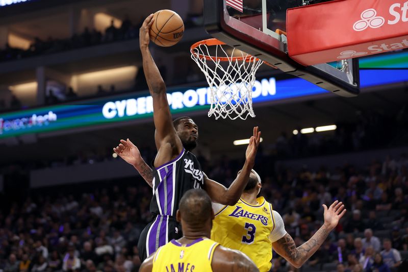 SACRAMENTO, CALIFORNIA - MARCH 13: Harrison Barnes #40 of the Sacramento Kings dunks the ball on LeBron James #23 and Anthony Davis #3 of the Los Angeles Lakers in the first half at Golden 1 Center on March 13, 2024 in Sacramento, California. NOTE TO USER: User expressly acknowledges and agrees that, by downloading and or using this photograph, User is consenting to the terms and conditions of the Getty Images License Agreement.  (Photo by Ezra Shaw/Getty Images)