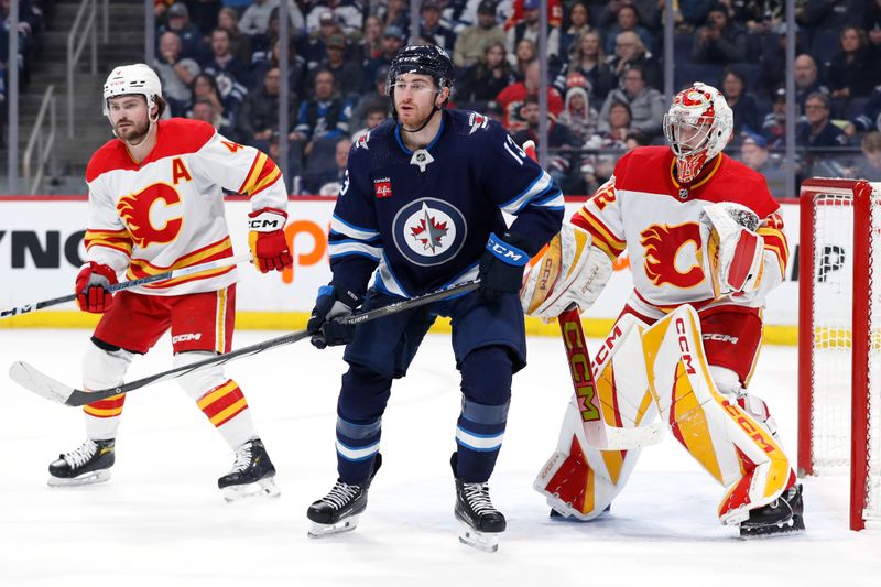 Apr 4, 2024; Winnipeg, Manitoba, CAN; Calgary Flames defenseman Rasmus Andersson (4), Winnipeg Jets center Gabriel Vilardi (13) and Calgary Flames goaltender Dustin Wolf (32) watch the play in the second period at Canada Life Centre. Mandatory Credit: James Carey Lauder-USA TODAY Sports