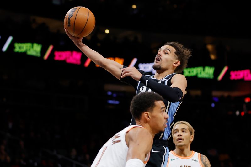 ATLANTA, GEORGIA - JANUARY 15: Trae Young #11 of the Atlanta Hawks shoots over Jeremy Sochan #10 of the San Antonio Spurs during the first half at State Farm Arena on January 15, 2024 in Atlanta, Georgia. NOTE TO USER: User expressly acknowledges and agrees that, by downloading and or using this photograph, User is consenting to the terms and conditions of the Getty Images License Agreement. (Photo by Alex Slitz/Getty Images)