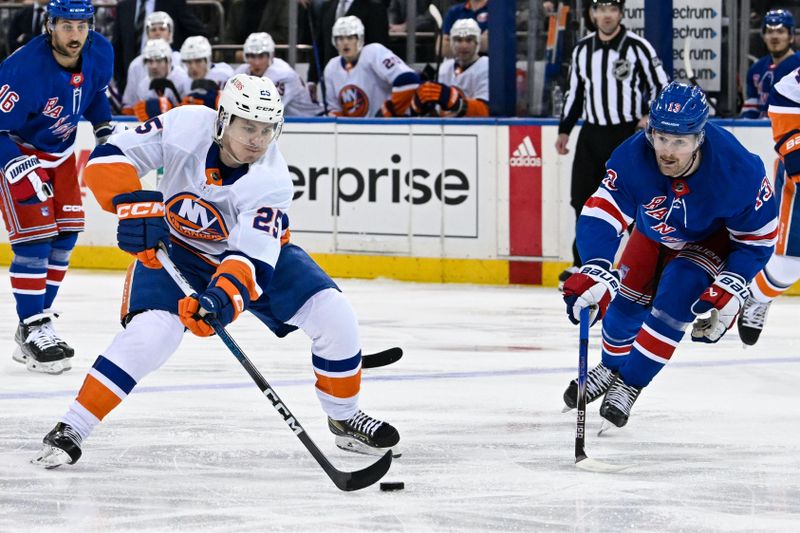 Apr 13, 2024; New York, New York, USA;  New York Islanders defenseman Sebastian Aho (25) skates the with the puck defended by New York Rangers left wing Alexis Lafrenière (13) during the first period at Madison Square Garden. Mandatory Credit: Dennis Schneidler-USA TODAY Sports