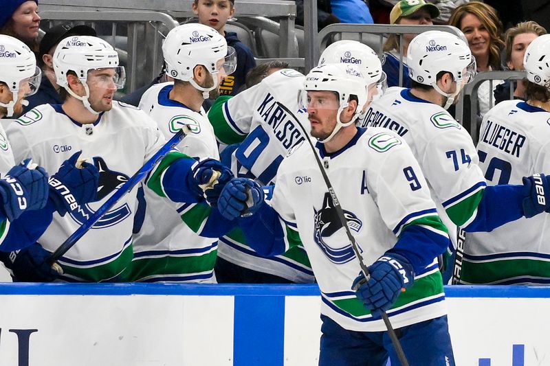 Jan 27, 2025; St. Louis, Missouri, USA;  Vancouver Canucks center J.T. Miller (9) is congratulated by teammates after scoring against the St. Louis Blues during the second period at Enterprise Center. Mandatory Credit: Jeff Curry-Imagn Images