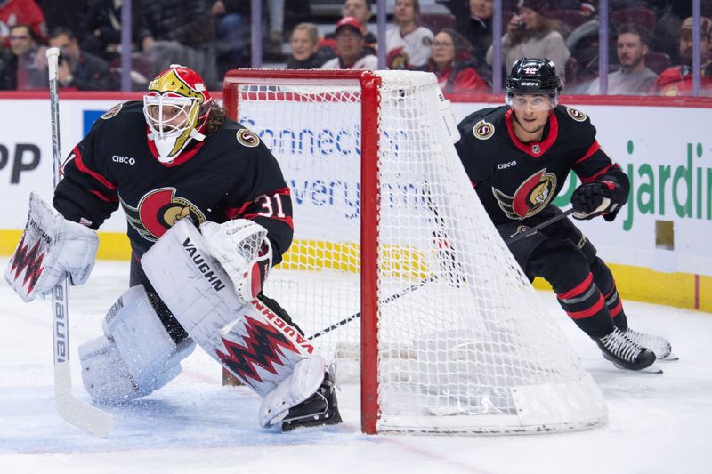 Jan 5, 2026; Ottawa, Ontario, CAN; Ottawa Senators goalie Hunter Shepard (31) follows the puck as center Shane Pinto (12) skates behind the goal in the second period against the Detroit Red Wings at the Canadian Tire Centre. Mandatory Credit: Marc DesRosiers-IMAGN Images