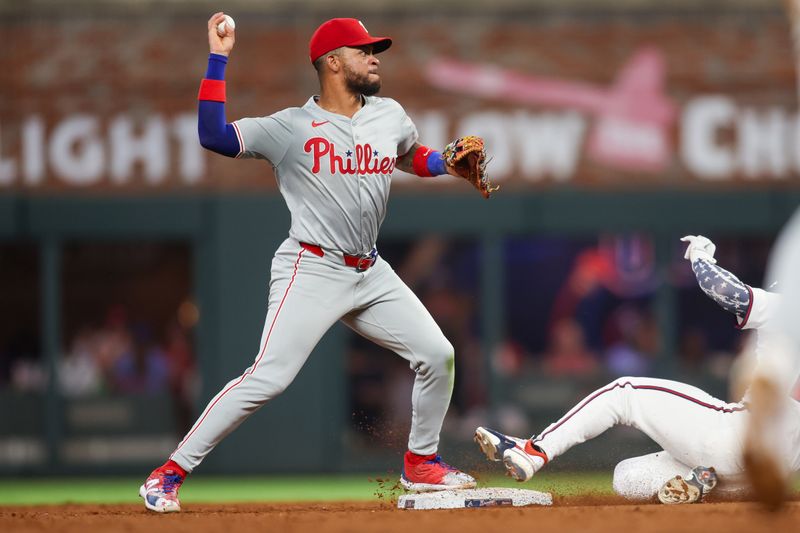 Aug 21, 2024; Atlanta, Georgia, USA; Philadelphia Phillies second baseman Edmundo Sosa (33) throws to first over Atlanta Braves left fielder Jarred Kelenic (24) in the sixth inning at Truist Park. Mandatory Credit: Brett Davis-USA TODAY Sports