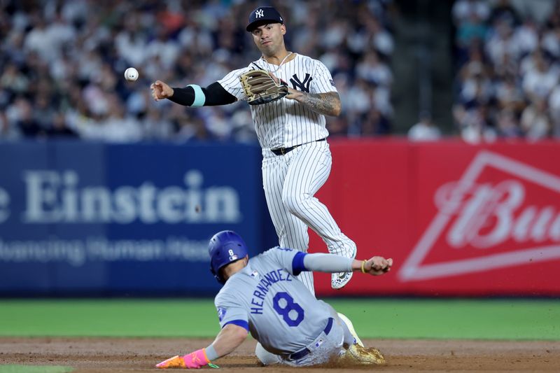 Jun 9, 2024; Bronx, New York, USA; New York Yankees second baseman Gleyber Torres (25) steps on second base to force out Los Angeles Dodgers third baseman Enrique Hernandez (8) and throws to first to complete a double play on a ball hit by Dodgers shortstop Mookie Betts (not pictured) during the seventh inning at Yankee Stadium. Mandatory Credit: Brad Penner-USA TODAY Sports