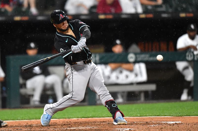 Jun 24, 2025; Chicago, Illinois, USA; Arizona Diamondbacks catcher Jose Herrera (11) hits a sacrifice RBI fly ball during the seventh inning against the Chicago White Sox at Rate Field. Mandatory Credit: Patrick Gorski-Imagn Images