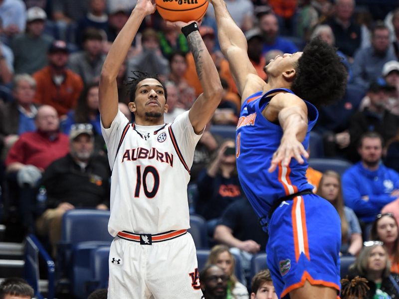 Mar 17, 2024; Nashville, TN, USA;  Auburn Tigers guard Chad Baker-Mazara (10) shoots against Florida Gators guard Zyon Pullin (0) in the first half against the Auburn Tigers in the SEC Tournament championship game at Bridgestone Arena. Mandatory Credit: Christopher Hanewinckel-USA TODAY Sports