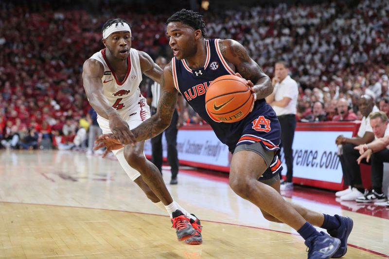 Jan 6, 2024; Fayetteville, Arkansas, USA; Auburn Tigers guard K.D. Johnson (0) drives against Arkansas Razorbacks guard Davonte Davis (4) during the first half at Bud Walton Arena. Mandatory Credit: Nelson Chenault-USA TODAY Sports