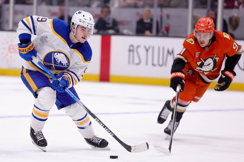 Nov 22, 2024; Anaheim, California, USA; Buffalo Sabres left wing Zach Benson (9) controls the puck ahead of Anaheim Ducks center Leo Carlsson (91) during the third period at Honda Center. Mandatory Credit: Ryan Sun-Imagn Images