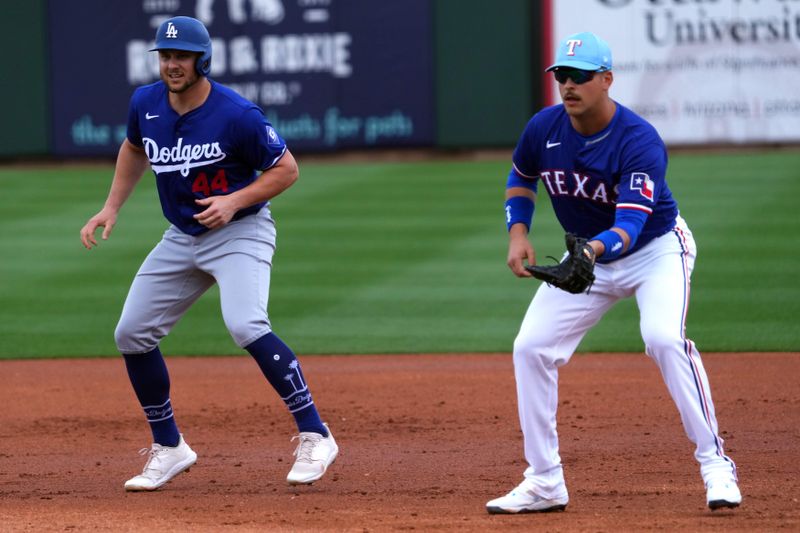 Feb 28, 2024; Surprise, Arizona, USA; Los Angeles Dodgers first baseman Kevin Paolo (44) leads off first as Texas Rangers first baseman Nathaniel Lowe (30) covers the bag during the second inning at Surprise Stadium. Mandatory Credit: Joe Camporeale-USA TODAY Sports