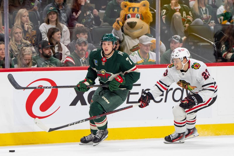 Oct 1, 2024; Saint Paul, Minnesota, USA; Minnesota Wild defenseman Brock Faber (7) is chased by Chicago Blackhawks center Philipp Kurashev (23) in the second period at Xcel Energy Center. Mandatory Credit: Matt Blewett-Imagn Images