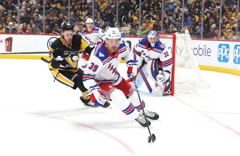 Jan 31, 2026; Pittsburgh, Pennsylvania, USA;  New York Rangers center Sam Carrick (39) skates with the puck ahead of Pittsburgh Penguins center Ben Kindel (81) during the first period at PPG Paints Arena. Mandatory Credit: Charles LeClaire-Imagn Images
