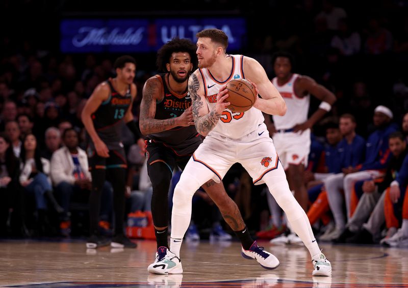 NEW YORK, NEW YORK - JANUARY 18:  Isaiah Hartenstein #55 of the New York Knicks looks to pass as Marvin Bagley III #35 of the Washington Wizards defends at Madison Square Garden on January 18, 2024 in New York City. NOTE TO USER: User expressly acknowledges and agrees that, by downloading and or using this photograph, User is consenting to the terms and conditions of the Getty Images License Agreement (Photo by Elsa/Getty Images)