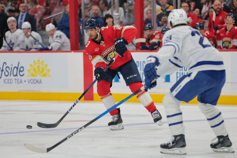 Apr 8, 2025; Sunrise, Florida, USA; Florida Panthers defenseman Seth Jones (3) passes the puck as Toronto Maple Leafs left wing Matthew Knies (23) defends during the second period at Amerant Bank Arena. Mandatory Credit: Sam Navarro-Imagn Images
