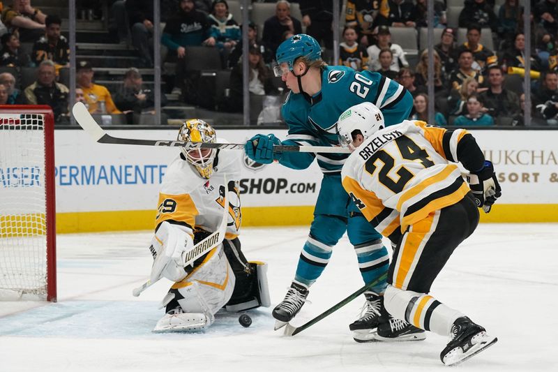 Jan 27, 2025; San Jose, California, USA;  San Jose Sharks left wing Fabian Zetterlund (20) shoots against Pittsburgh Penguins defenseman Matt Grzelcyk (24) and goalie Alex Nedeljkovic (39) in the second period at SAP Center at San Jose. Mandatory Credit: David Gonzales-Imagn Images