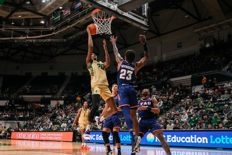 Jan 6, 2024; Charlotte, North Carolina, USA; Charlotte 49ers forward Robert Braswell IV (20) gets the basket over Florida Atlantic Owls guard Brandon Weatherspoon (23) during the first half at Dale F. Halton Arena. Mandatory Credit: Jim Dedmon-USA TODAY Sports